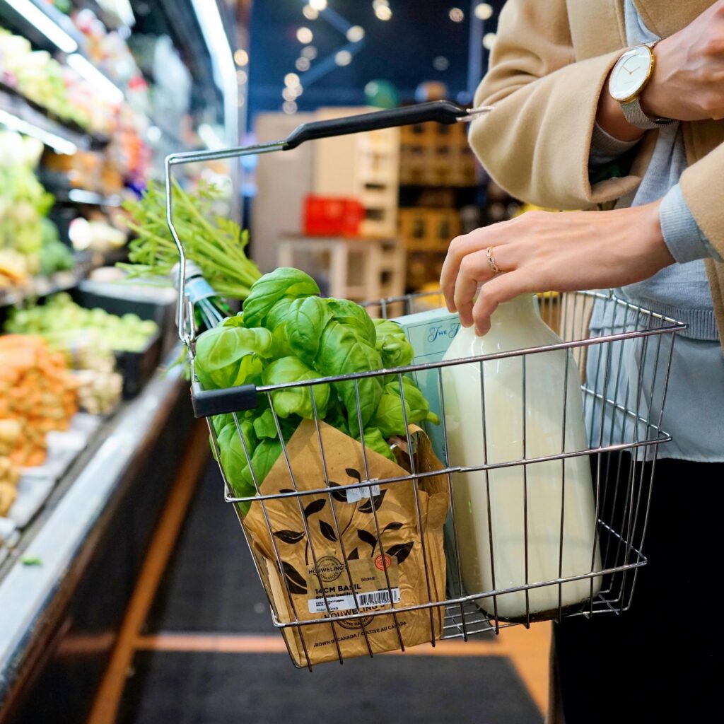 A Close-Up Shot of a Person in a Grocery store shopping for goat milk and other products.